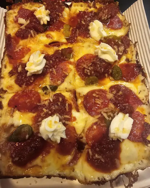 Prostokątna pizza Detroit z pepperoni i ricottą, z przypieczonym serem na brzegach